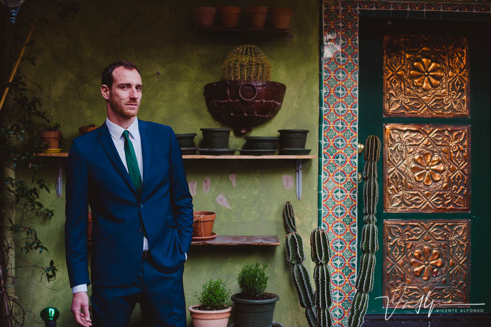 Hombre elegante y trajeado mirando a cámara junto a restaurante Mexicano