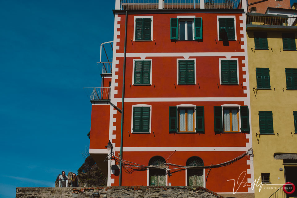 Pareja junto a edificio de colores en Cinque Terre