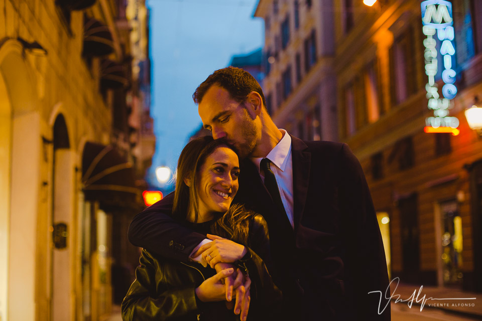 Novio besando novia en la calle principal por la noche en Genoa