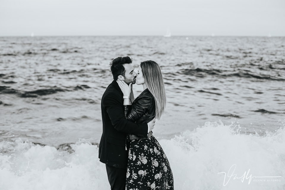 Pareja besándose dentro del agua en la playa de Barcelona