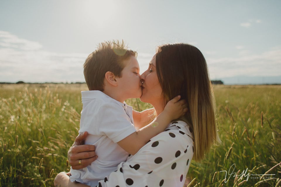 Hijo besando a su madre en la boca en el campo