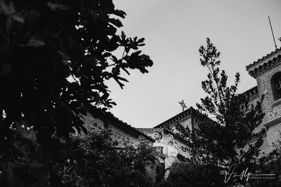 Pareja entre los árboles con la iglesia de Chilla al fondo en Candeleda