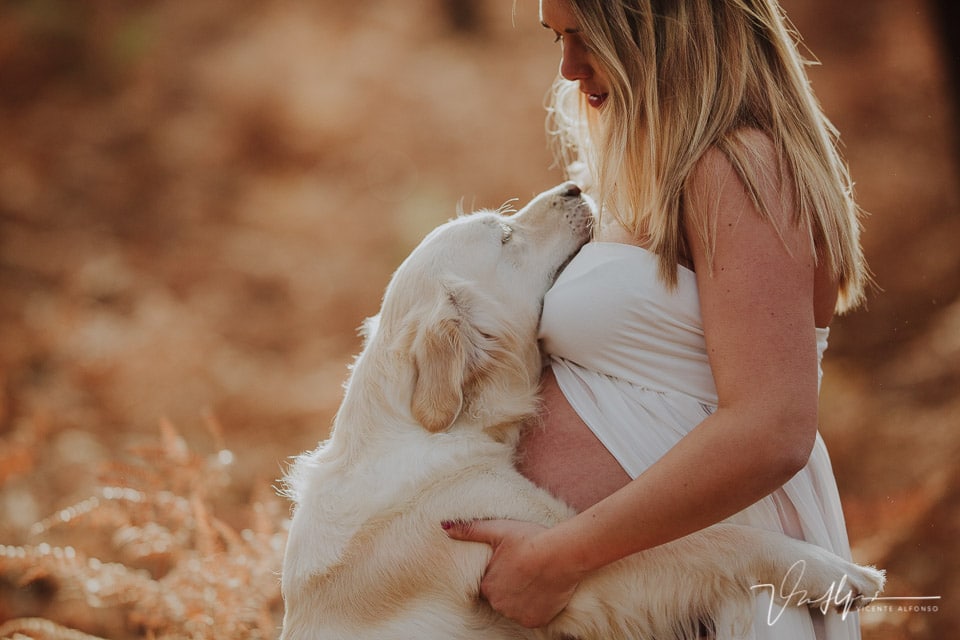 Embarazada abrazando a su perro en la Sierra