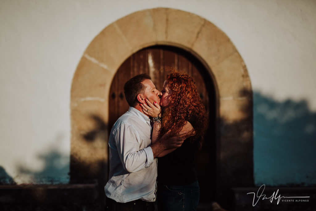 pareja besándose junto a la puerta de un convento